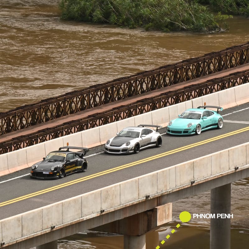 Three cars crossing river bridge